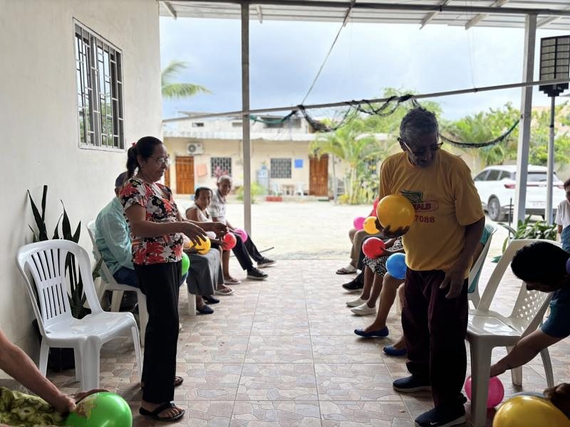 Adultos mayores hacen ejercicio con pelotas de colores