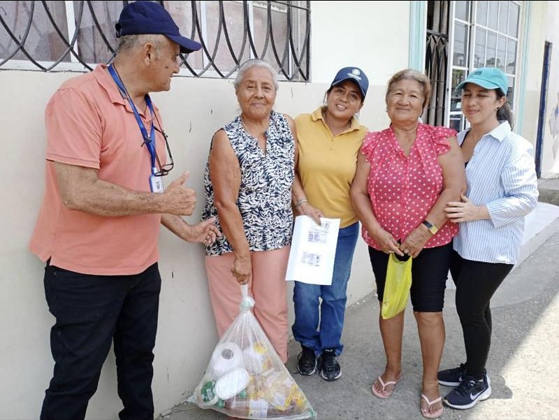 Adultas mayores reciben su kit frente a su casa