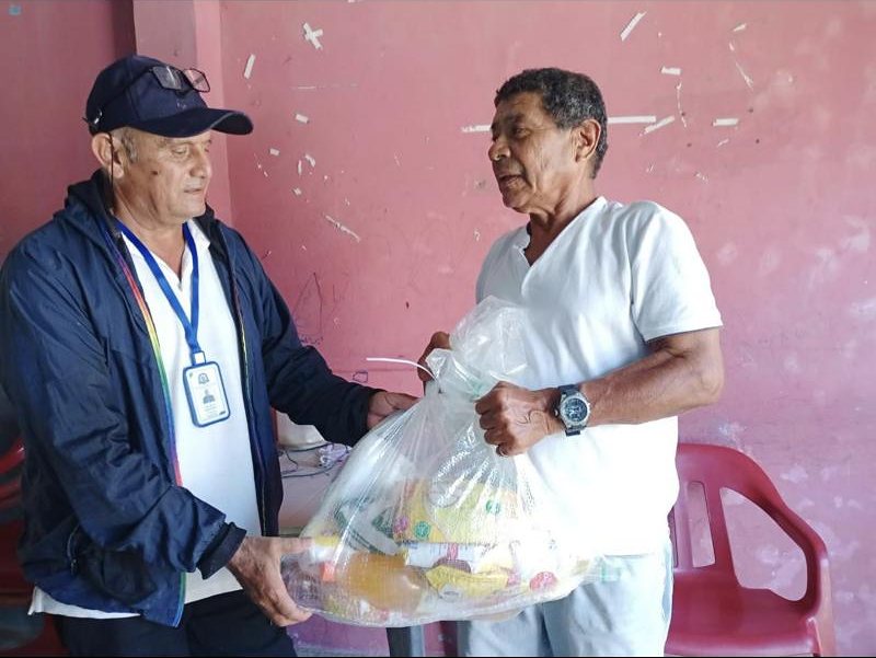 Un adulto mayor recibe un kit de alimentos